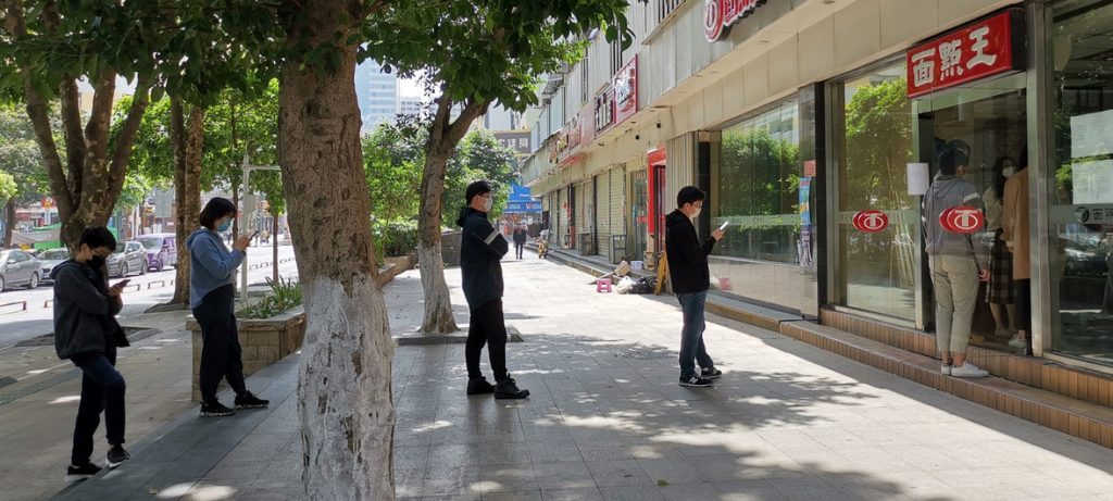 Durante o surto de coronavírus, pessoas em Shenzhen, na China, mantêm distância uma das outras em uma fila enquanto esperam para pedir comida para viagem. Foto: Man Yi