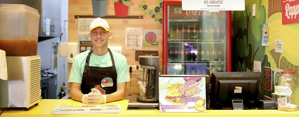 César Jiménez Martínez, surdo desde que nasceu, trabalha na rede de hamburguerias Sierra Nevada, em Bogotá, Colômbia. Crédito: ACNUR / Daniel Dreifuss.