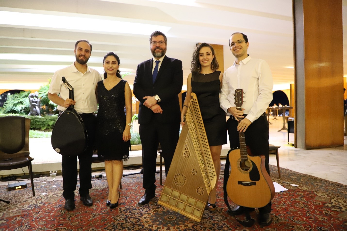 Os sírios Abdul, Lucia e Miriam e o venezuelano Oscar são cumprimentados pelo ministro das Relações Exteriores do Brasil, Ernesto Araújo (ao centro), após apresentação musical. Foto: ACNUR/Victoria Hugueney