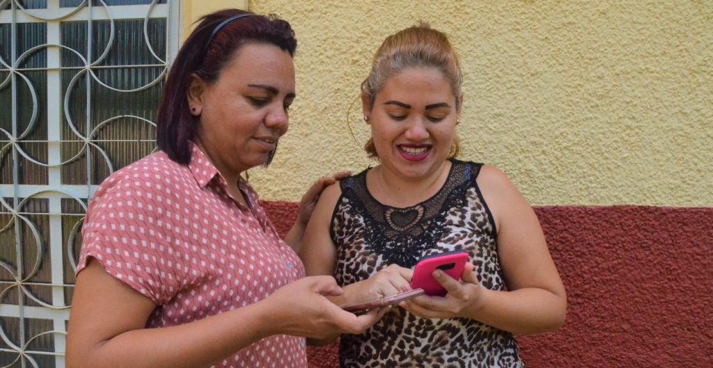 Do WhatsApp até descontos no supermercado, as venezuelanas Jessica e Jennifer usam seus smartphones para acessar direitos, serviços e se comunicar com as famílias, que vivem em outros países. Foto: ACNUR/Victoria Hugueney