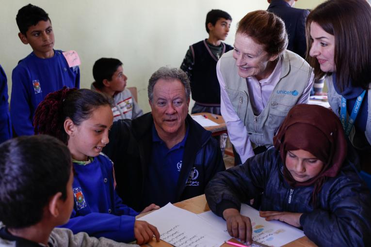 Em 3 de março de 2020 na Síria, o diretor executivo do PMA, David Beasley (sentado, no centro), e a diretora executiva do UNICEF, Henrietta H. Fore (em pé, segundo da direita), visitam crianças da terceira série na escola Tal-Amara no sul rural de Idlib. Foto: UNICEF