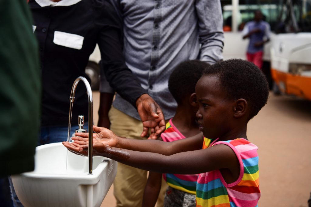 As irmãs gêmeas Emeline e Eveline lavam as mãos em uma estação pública instalada como medida preventiva contra o coronavírus no Nyabugogo Bus Park, em Ruanda. Foto: Ritzau Scanpix