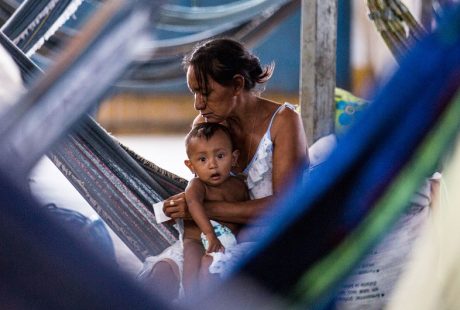 Uma mãe cuida de seu bebê dentro de um ginásio que foi transformado em assentamento de refugiados em Boa Vista (RR). Foto: ACNUR/Vincent Tremeau