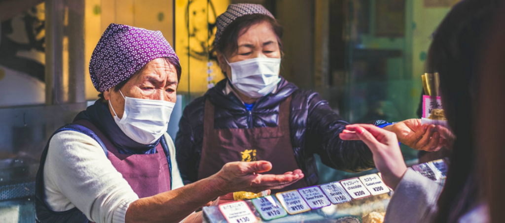 Vendedoras usam máscaras em um mercado de alimentos no Japão. Foto: Unsplash/Jérémy Stenuit