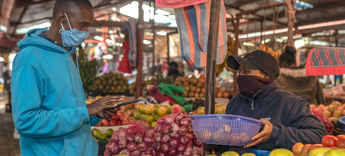 Homem compra produtos frescos num Mercado no Quênia. Foto: Sambrian Mbaabu/Banco Mundial