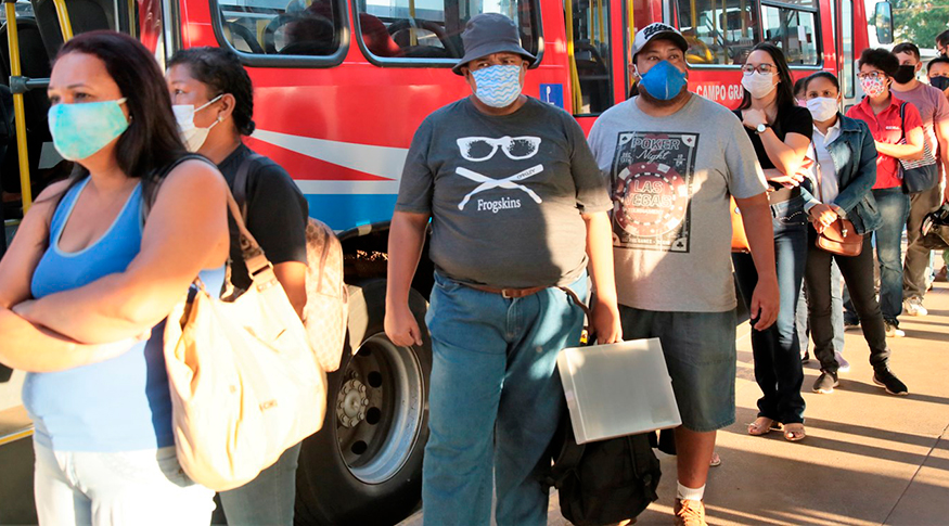 #PraCegoVer pessoas usando máscaras em fila de ônibus