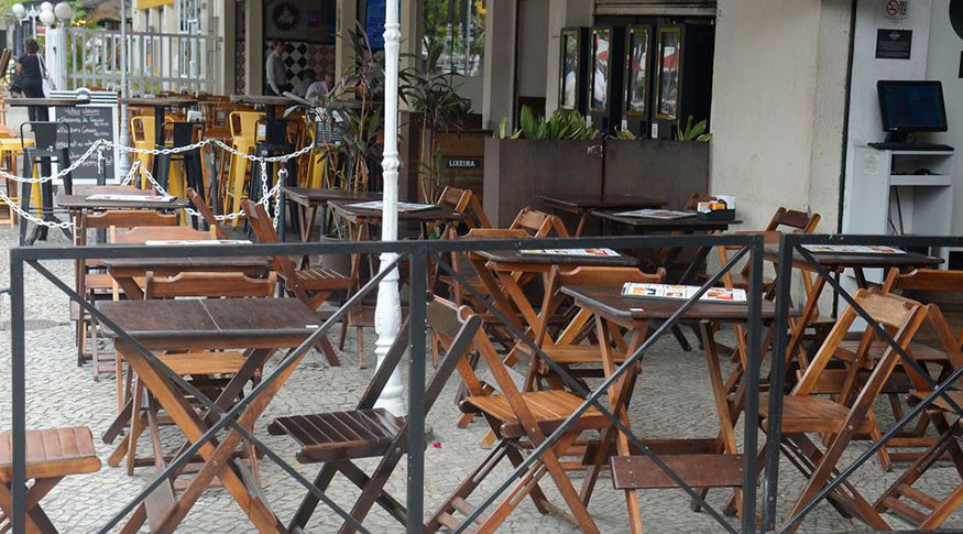 #PraCegoVer A foto mostra uma rua com restaurantes vazios