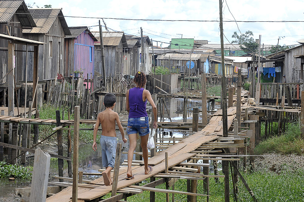 Em meio à falta de saneamento, moradores equilibram-se em 'ruas' de madeira para chegar a suas casas em Altamira, no Pará. Foto: Valter Campanato/ABr