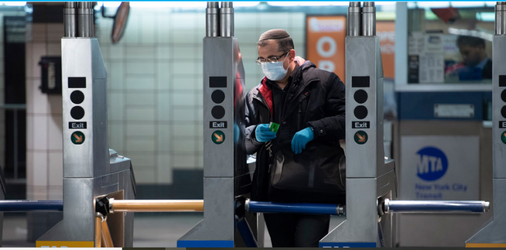 Homem usa máscara e luvas ao entrar no sistema de metrô durante a pandemia de COVID-19 em Nova Iorque. Foto: ONU/Evan Schneider