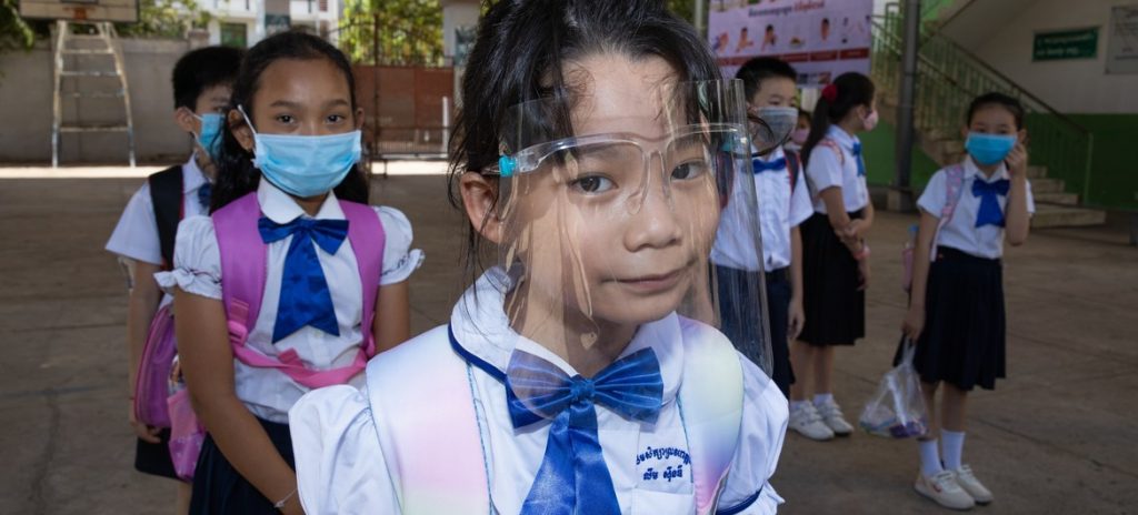 Alunos de uma escola primária em Phnom Penh, Camboja, no segundo dia após a reabertura da escola. Alunos, professores e administradores escolares usam máscaras e mantêm o distanciamento físico. Foto: UNICEF/Seyha Lychheang