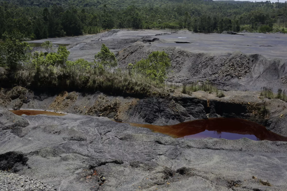 Cenário de rejeitos da mineração de carvão com cratera exposta há anos