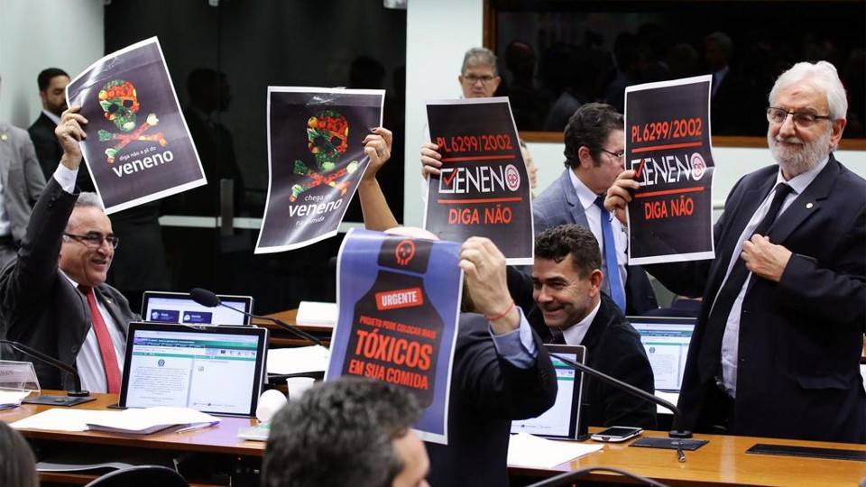 Deputados segurando cartazes contra o PL.6.299, com dizeres como "Veneno não"