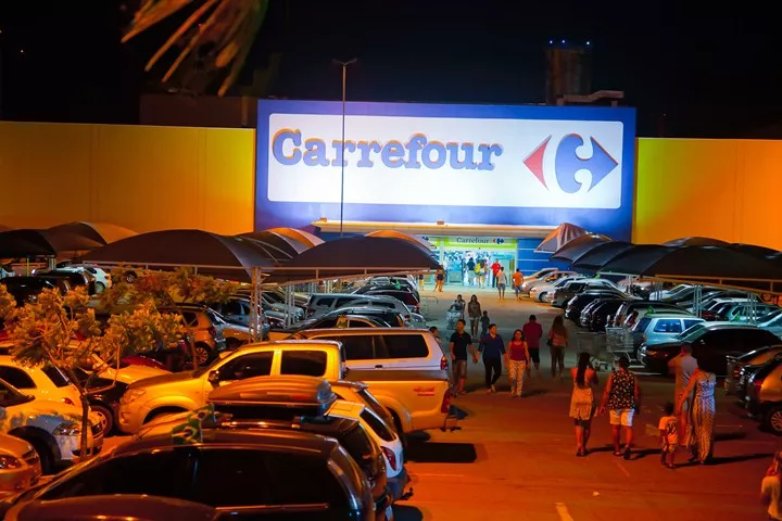 Imagem mostra a entrada de uma unidade do Carrefour com estacionamento na frente