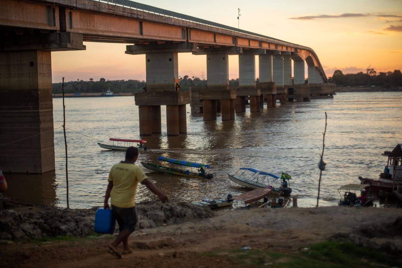 Usina Hidrelétrica de Santo Antonio no Rio Madeira, em Porto Velho-RO; na foto é possível ver alguns barcos pequenos na água, além de um homem andando em direção a margem