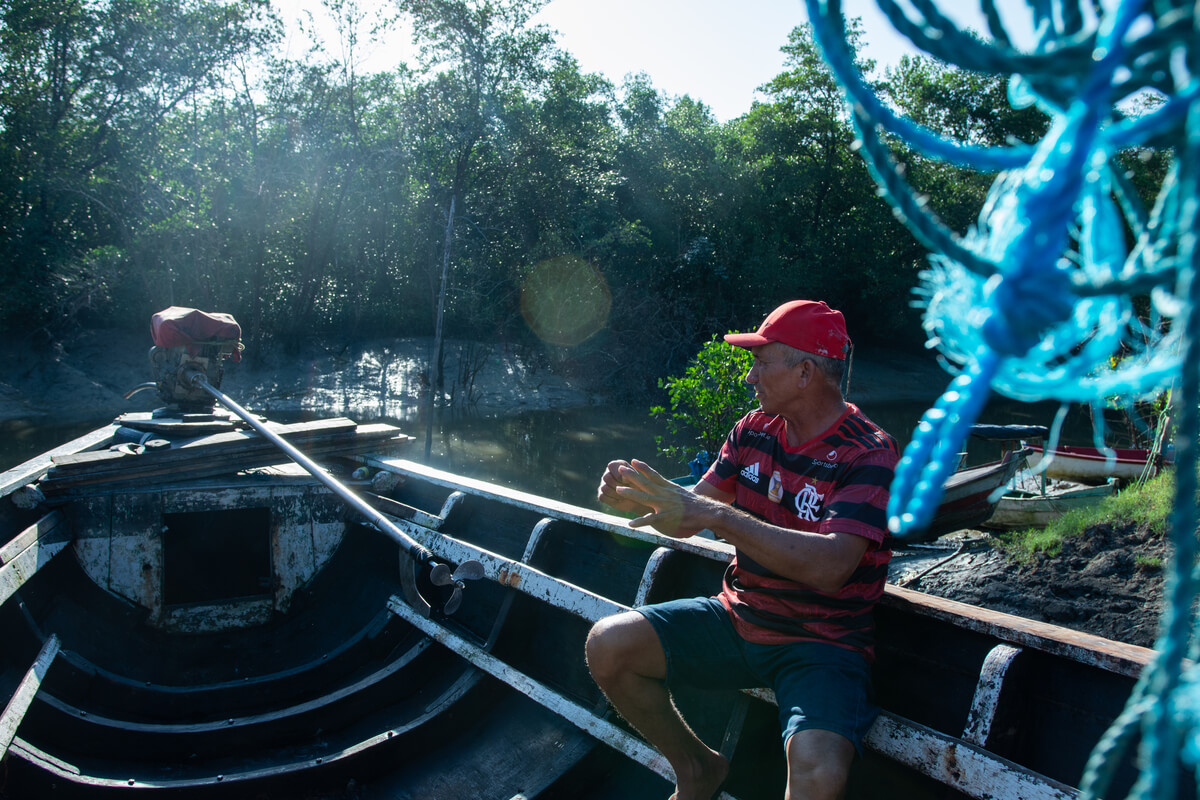 Pescador está em um barco no rio