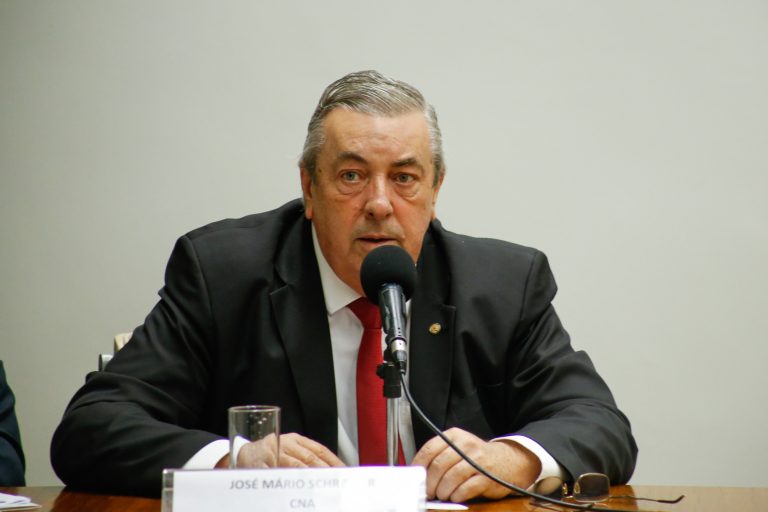 Deputado Jose Mario Schreiner fala ao microfone. Ele é branco, tem o cabelo grisalho e usa um terno preto