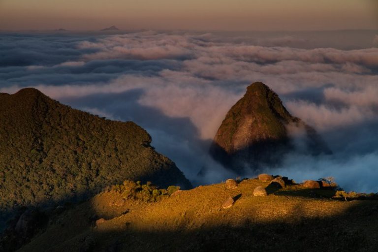 Vista aérea de morros com matas e nuvens no cume