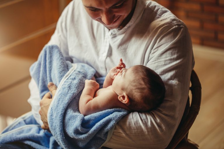 Pai segura um bebê recém-nascido