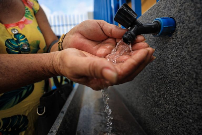 Mulher lava a mão na água que corre de uma torneira