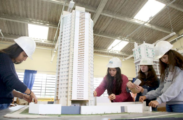 Alunas mexem em maquete de um prédio