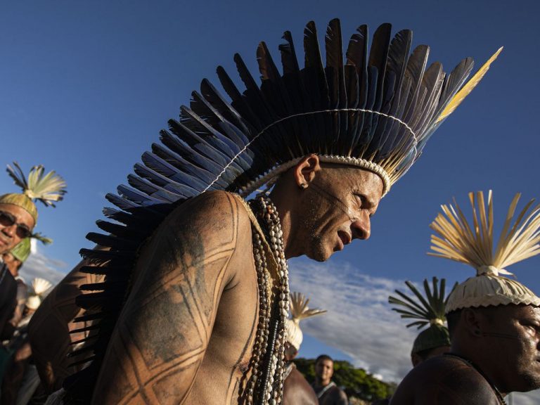 Índios com cocar num dia de sol