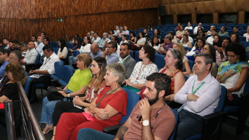 Auditório lotado com público atento as explicações.