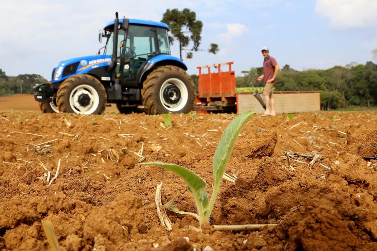 Produtor rural plantando com trator